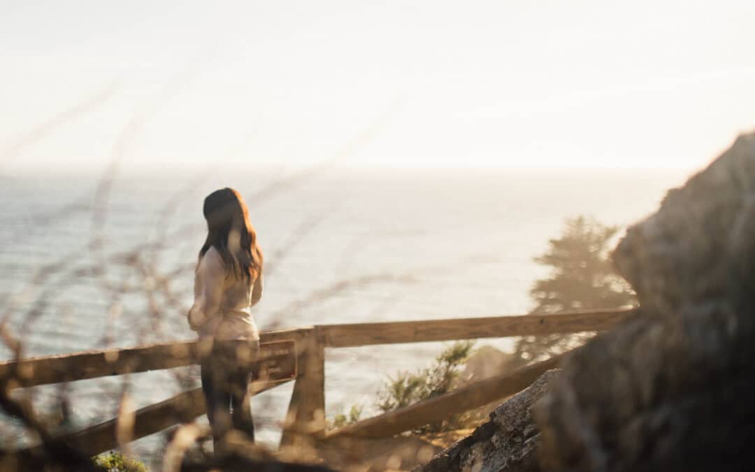 Woman standing at a cliff looking at the view
