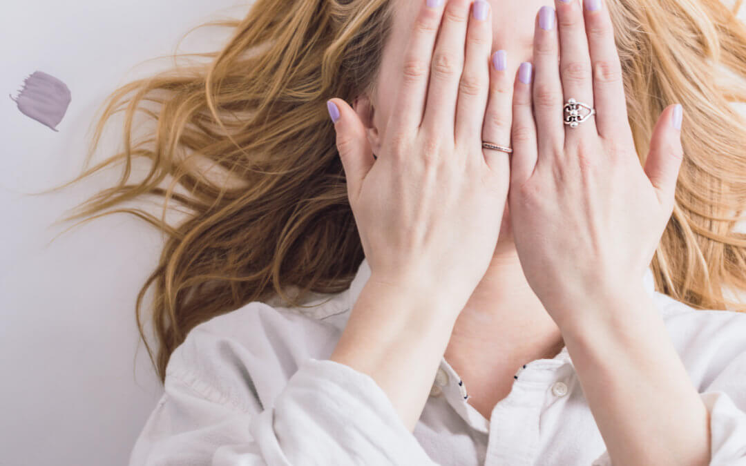 woman covering face with hands