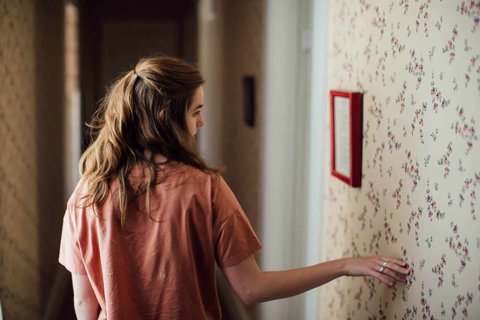 woman stopping to look at a framed piece on the wall